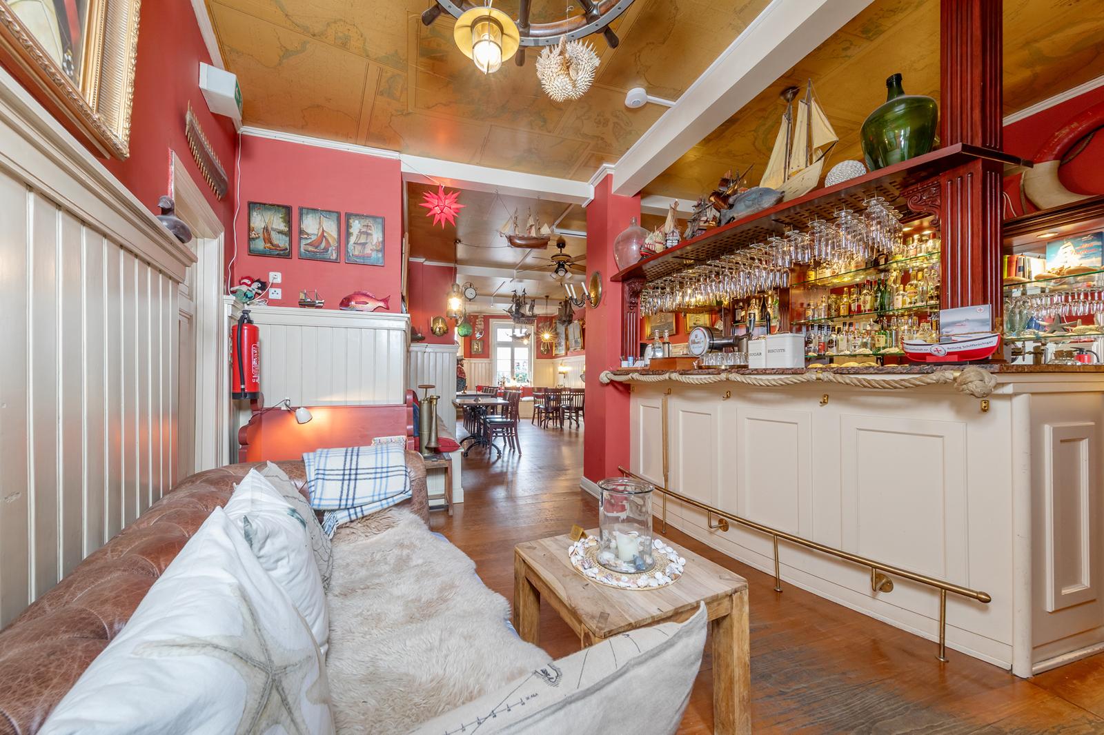 Kapitänsmesse mit Bar, Holztischen und maritimer Deko